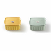 Two square containers, one yellow and one green, on a white background
